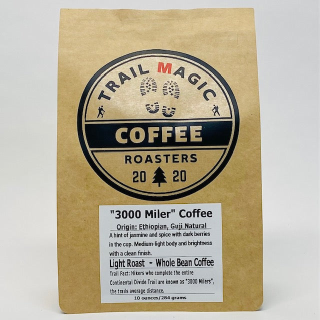 Kraft paper coffee bag with 'Trail Magic Coffee Roasters' branding on a white background